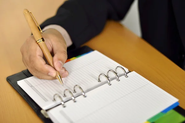 Uomo d'affari che scrive in agenda — Foto Stock