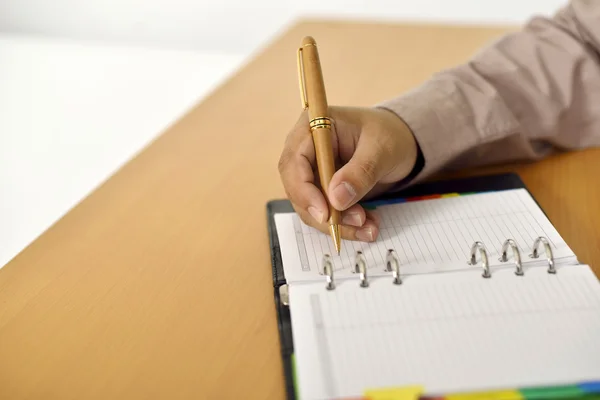 Uomo d'affari che scrive in agenda — Foto Stock