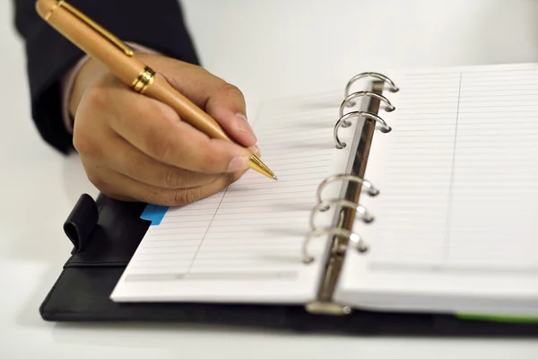 Hombre de negocios escribiendo en la agenda — Foto de Stock