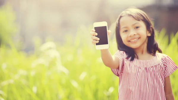 Glad flicka som leker utomhus med mobiltelefon — Stockfoto