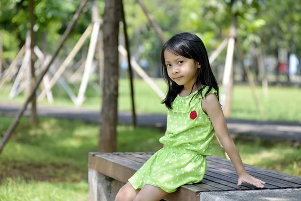 Маленькая девочка сидит снаружи — стоковое фото