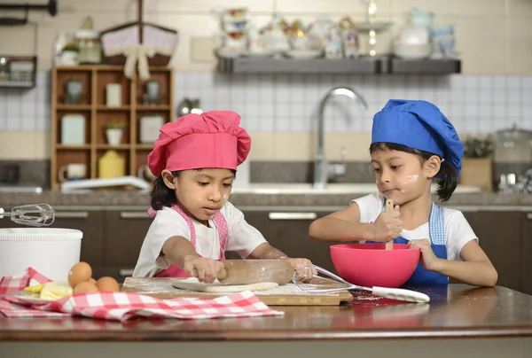Две маленькие девочки делают пиццу — стоковое фото