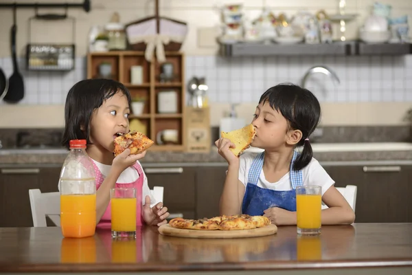 Две маленькие девочки едят пиццу — стоковое фото