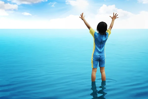 Ein kleines Mädchen blickt auf den Ozean — Stockfoto