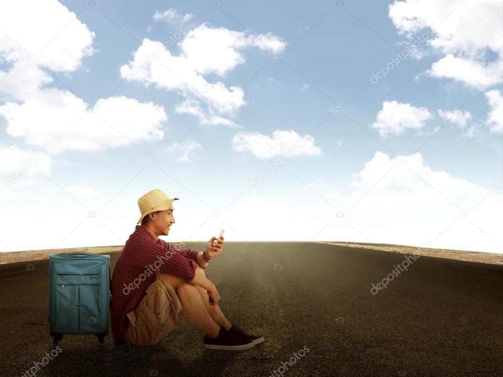 Man Sitting On The Road Using His Cellphone