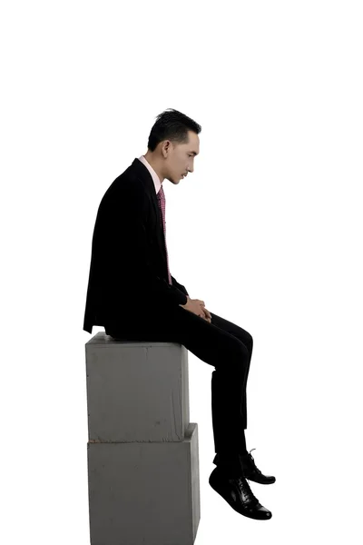 Ασιατικός επιχειρησιακός άνθρωπος αισθήματος των λυπημένων κάθεται στο πλαίσιο — Φωτογραφία Αρχείου