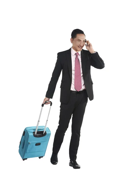 Hombre de negocios caminando con maleta y hablando por celular — Foto de Stock