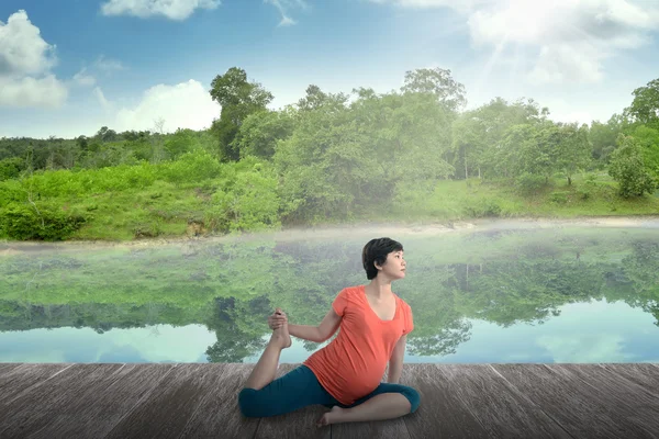 Gravida mamma gör yoga vid sjön — Stockfoto