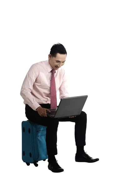 Hombre trabajando con el ordenador portátil sentado en la maleta —  Fotos de Stock