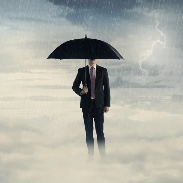 Business man with umbrella standing on the cloud with thunder Stock Picture