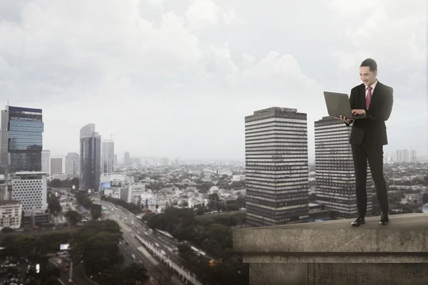 Asiático homem de negócios usando laptop no telhado — Fotografia de Stock