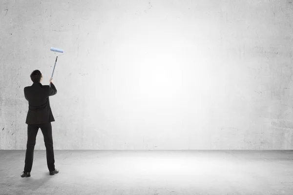 Hombre de negocios pintar algo en la pared vacía — Foto de Stock