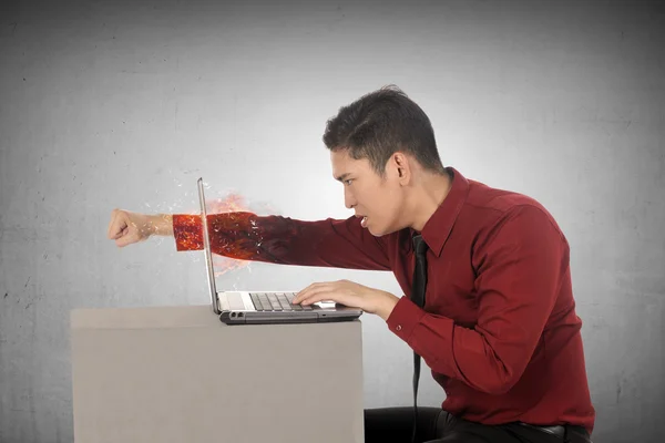 Business man throws a punch into the laptop — Φωτογραφία Αρχείου