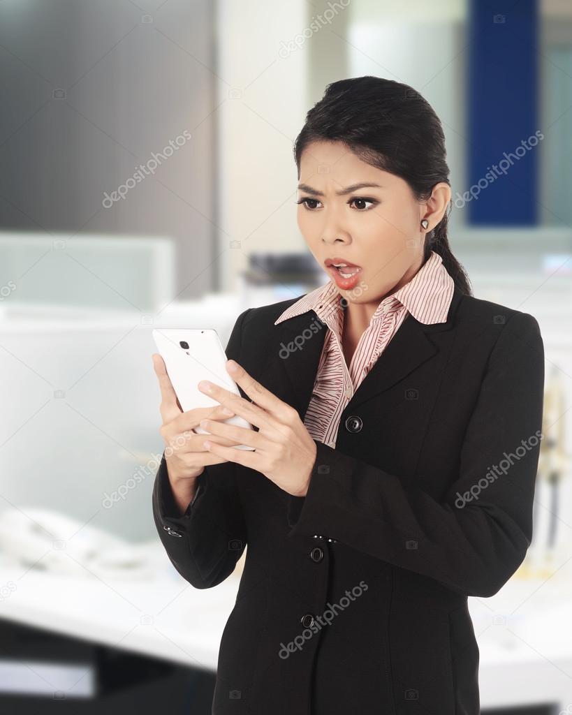Asian woman surprise looking at her cellphone