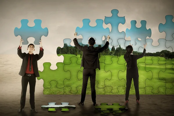 Lavoro di squadra di business assemblaggio pezzi puzzle creare ambiente verde — Foto Stock