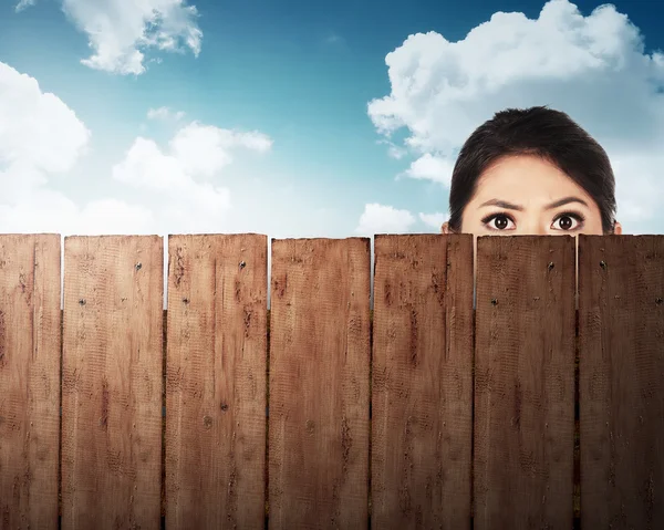 Une tête de femme derrière une clôture en bois — Photo