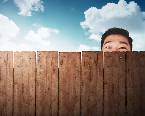 Una cabeza de hombre detrás de una cerca de madera —  Fotos de Stock