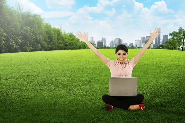 Vrouw die werkt met laptop op het gras — Stockfoto