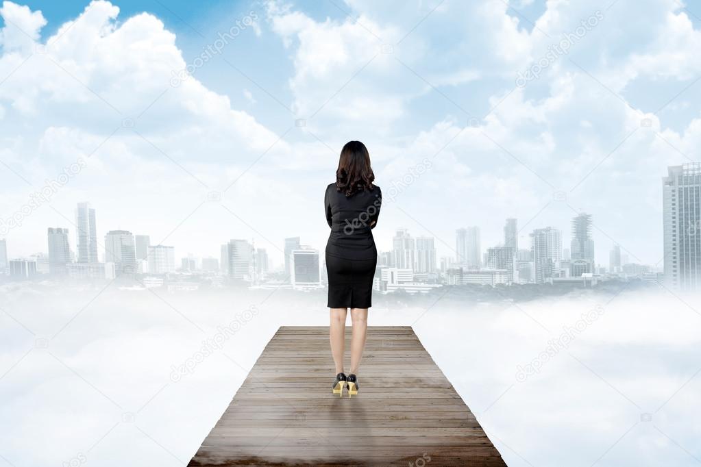 business woman looking the city from wooden pier
