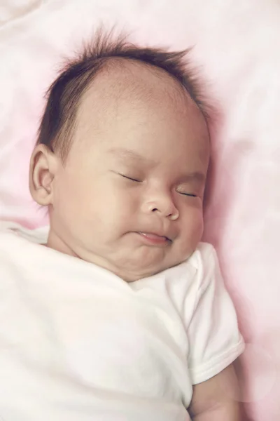 Bebé tranquilo acostado en una cama mientras duerme — Foto de Stock