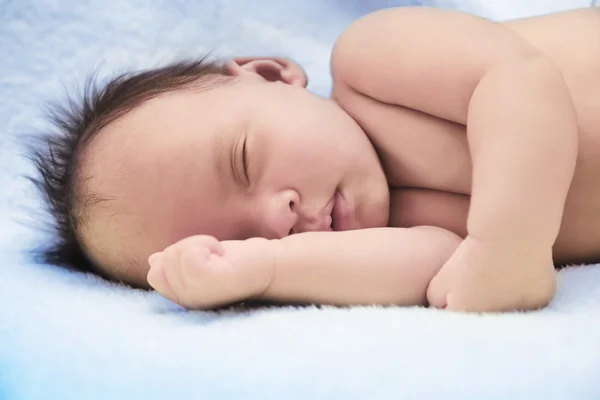 Bebé tranquilo acostado en una cama mientras duerme — Foto de Stock