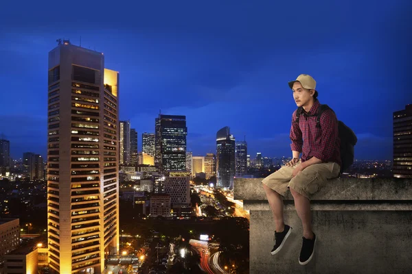 Male tourist sitting on the building rooftop