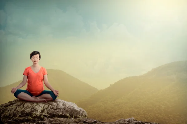 Zwangere vrouw doen yoga op de berg — Stockfoto