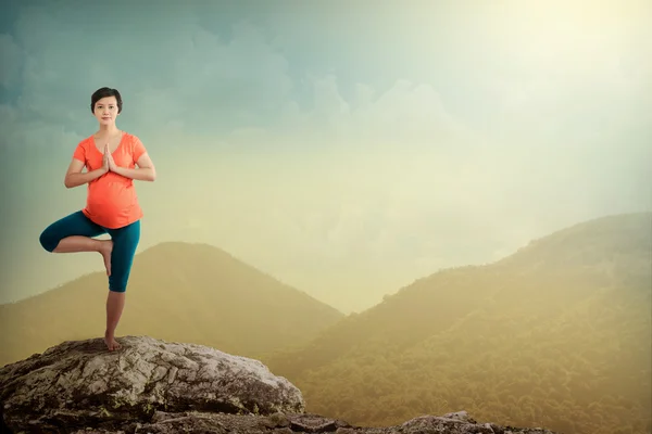 Gravid kvinna gör yoga på berget — Stockfoto