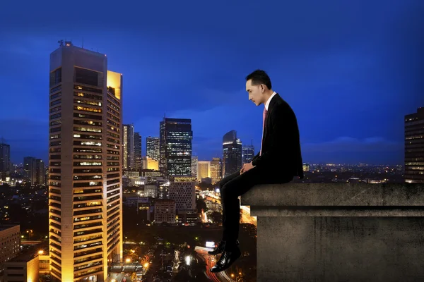 坐在大厦天台的商人 — 图库照片