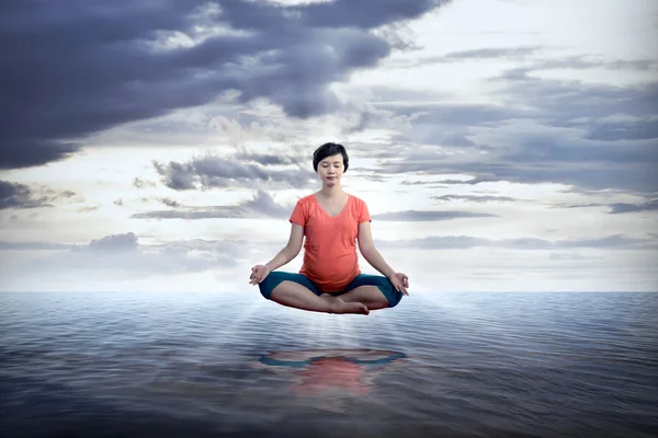 Pregnant mother doing yoga on the sea — Stock Photo, Image