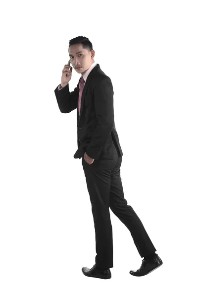Uomo d'affari che cammina mentre parla via cellulare — Foto Stock