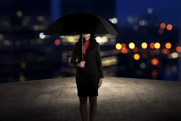 Affärskvinna som innehar paraply på taket — Stockfoto