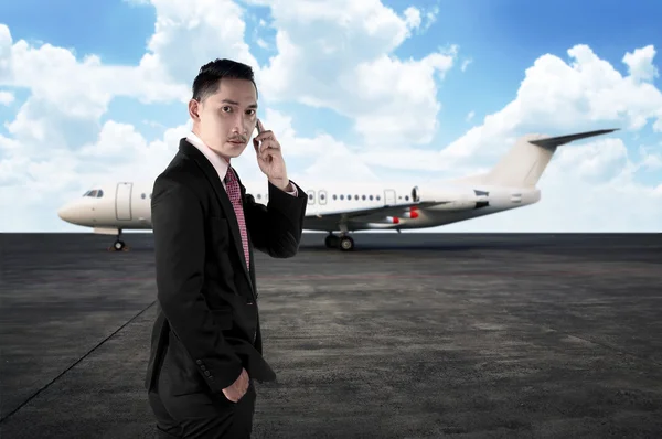 Homem de negócios chamando por telefone ao caminhar para o avião — Fotografia de Stock