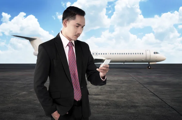 Företag man ringer via telefon när man går till planet — Stockfoto