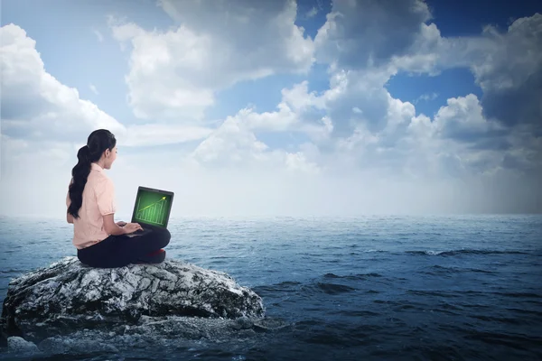 Business woman sitting on the top of the rock — Stock Photo, Image