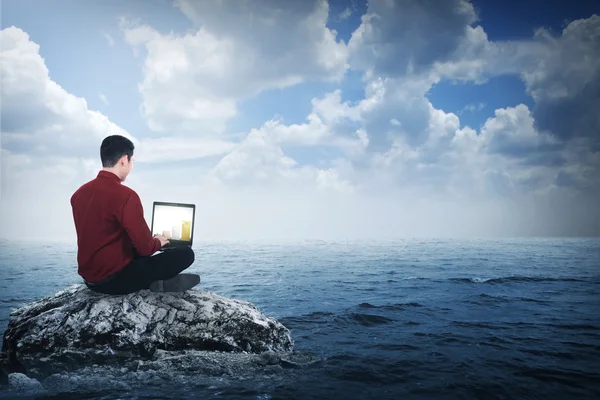 Business man sitting on the top of the rock — Stock Photo, Image