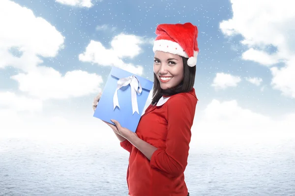 Asian woman in santa hat holding gift — Stock Photo, Image