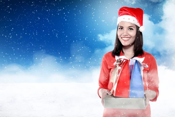 Asian woman in santa hat holding gift — Stock Photo, Image