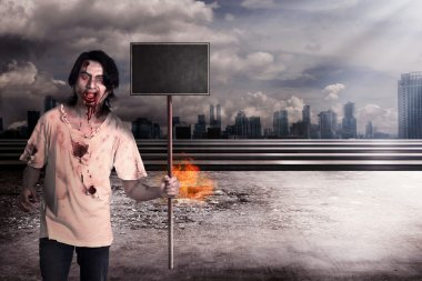 Erkek zombi holding ahşap yönetim kurulu üzerinde Şehir yanıyor