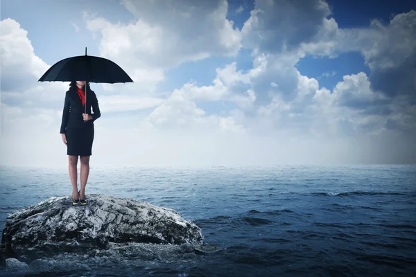 Frau hält Regenschirm im Meer — Stockfoto