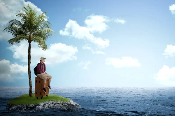 Asiatischer Tourist sitzt auf der kleinen Insel auf dem Koffer — Stockfoto