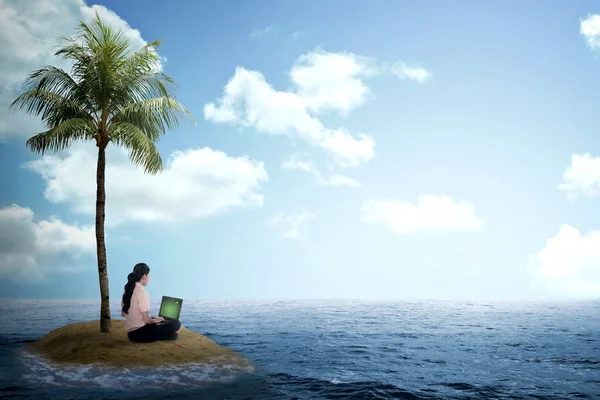 Business woman working with laptop on the small island — Stock Photo, Image