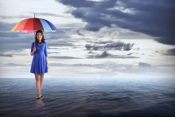 Mulher segurando guarda-chuva no mar — Fotografia de Stock