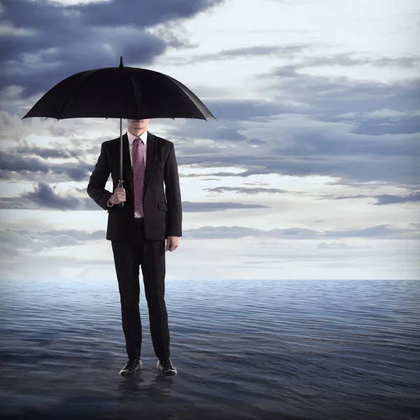 Mannen innehar paraply i havet — Stockfoto