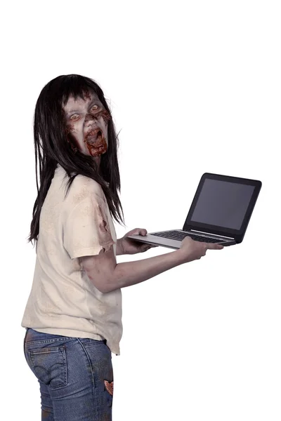 Scary female zombie holding laptop — Stock Photo, Image