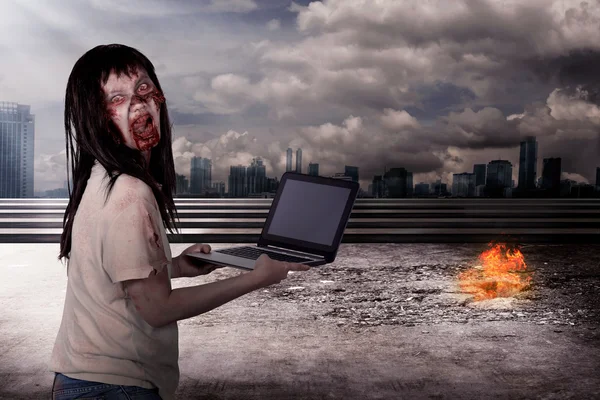 Gruselige Zombieweibchen tippen mit Laptop — Stockfoto