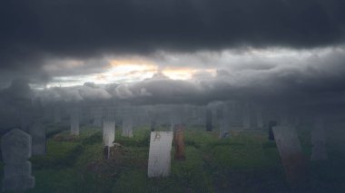 Mezarlıktaki dramatik gökyüzü arkaplanlı eski mezar taşları. Sahne korkutucu ve gizemli. Dramatik duman ya da sis etkisi. Modelleme. Uzayı kopyala Duvar kağıdı veya Cadılar Bayramı arkaplanı