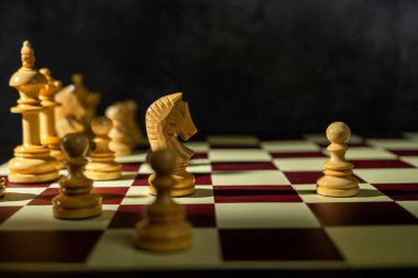 Satranç tahtasındaki karşı taşlara karşı duran beyaz bir satranç piyonunun yakın görüntüsü. Strateji kavramı