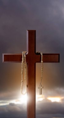 Hristiyan haçı ve manzara manzaralı tespih boncukları ve karanlık, dramatik bir arka plan. Hıristiyanlık, din, inanç, İsa veya inanç kavramı