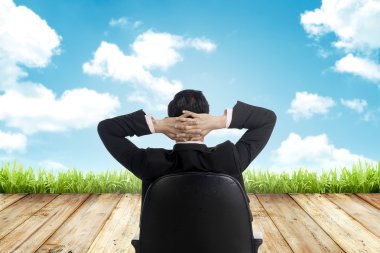 Adam gökyüzüne bakarak sandalyede oturmak